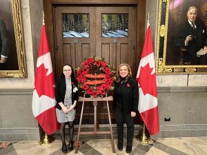 Morgan Hussey and the Honourable Lena Metlege, standing because a wreath of Poppies