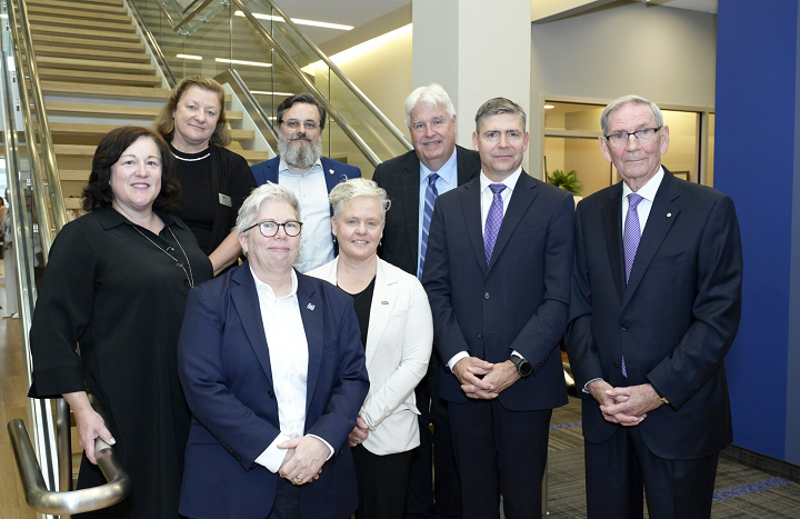 Dr. Joël Dickinson, alongside several executives from Shannex, posing in front of the stairs at the Shannex head office