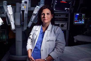 Dr. Stephanie Scott standing in front of medical equipment in a research lab