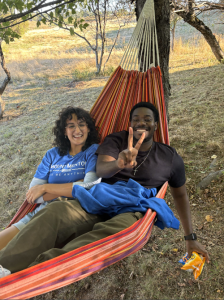 Lily Brigham-Gale and another student sitting in a hammock on campus
