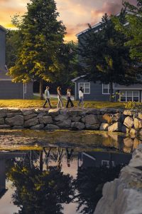Lily Brigham-Gale and other students walking around the pond near the residence buildings