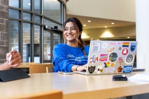 Simranpreet Kaur sitting in McCain Centre in front of their laptop