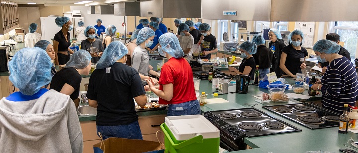 Students in a nutrition lab during the CHOPPED challenge, preparing various meals