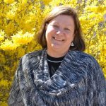 Janice Keefe, standing outside near a yellow maple tree