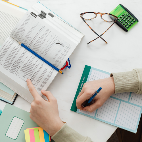 A MSVU post-secondary student reviewing a textbook while making notes