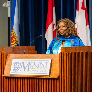 Ann Divine, the recipient of degree of Doctor of Humane Letters, honoris causa, at the Fall 2025 Convocation ceremony, speaking at the podium