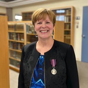Dr. Jamie Metsala, wearing the King Charles medal, smiling at the camera
