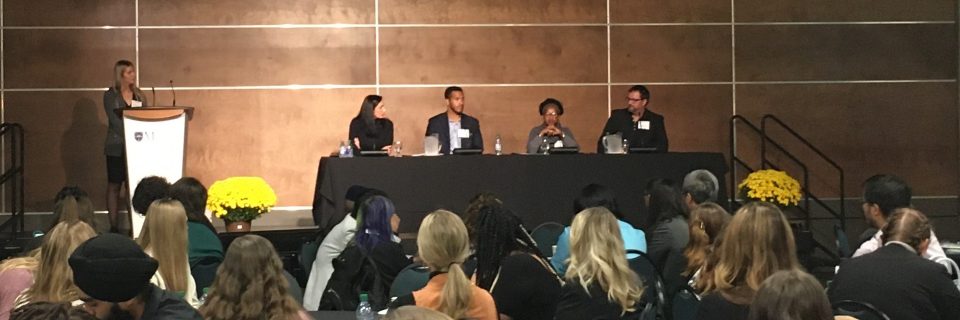 MSVU CEO panel session from Learners and Leaders conference in 2022. Four panelists sitting on the stage in the MPR in front of a table with the moderator on the left.