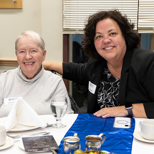 Susan and Robyn McIsaac, standing sitting down at a table