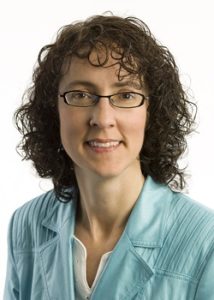 Claudette Porter, wearing a teal blazer and black glasses