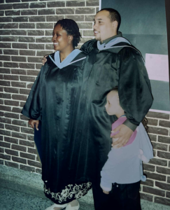 Martin Morrison, posing away from the camera for a photo, hugging two other people.