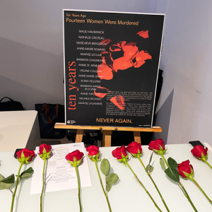 Roses placed in front of a sign for the National Day of Remembrance & action on violence against women