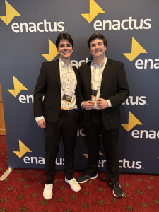 Tanner, on the right, standing alongside a student at an enactus event