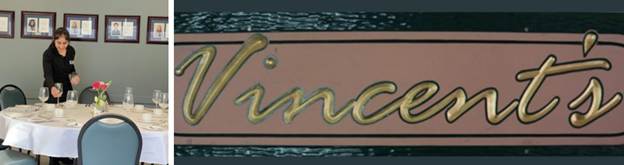 A student placing a glass on a table, to the right, a glossy wood painted black around the edges with the word Vincent's centered in the middle in gold on a beige oval in cursive writing.