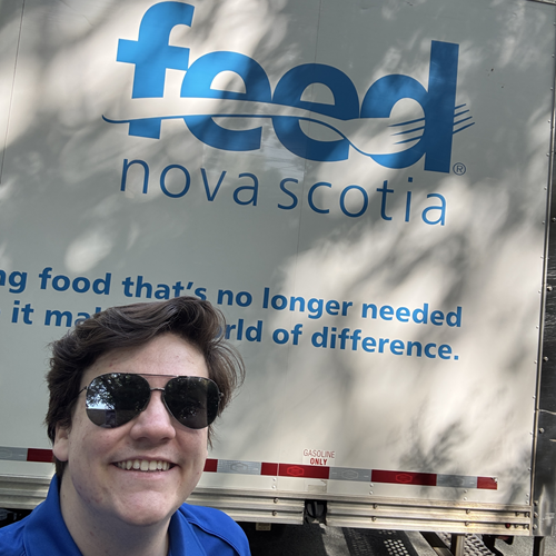 Tanner Saunders posing in front of a Feed Nova Scotia truck