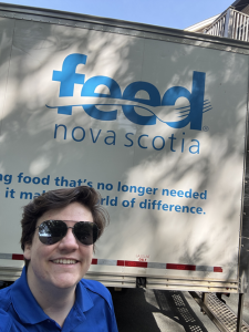 Tanner Saunders posing in front of a Feed Nova Scotia truck