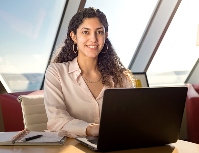 A student working in an office on a laptop while on their co-op work term