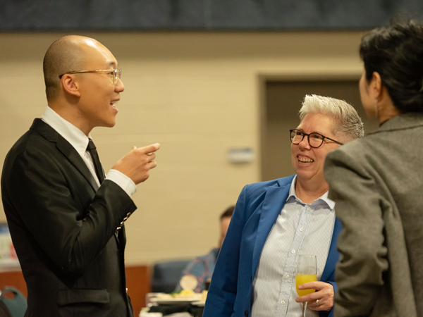 Cong Chen speaking with President Joël Dickinson and others at an award ceremony