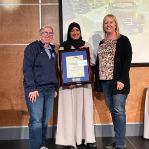 Nouf Saleh holding an award. To the left of them is MSVU President Joël Dickinson and to the right is Kim Peitzsche.