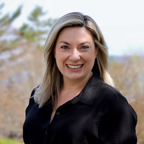 Dr Kyly Whitfield, posing for a photo on the MSVU campus, wearing a black blazer