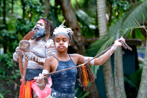 Two members of the Aboriginal and Torres Strait Islander peoples of Australia, holding a whip and an instrument