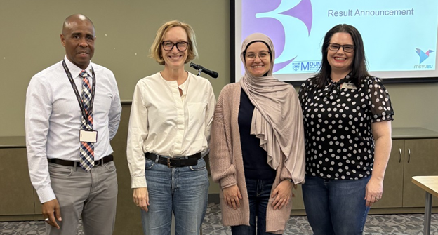 Dina Sallam, second from right, standing beside the Three Minute Thesis competition judges