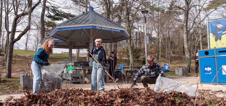 Several students raking leaves near Bill Morris Square