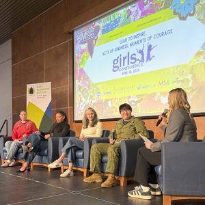 The four panelists and moderated by Abbie McDonough, speaking on stage at the Girls Conference