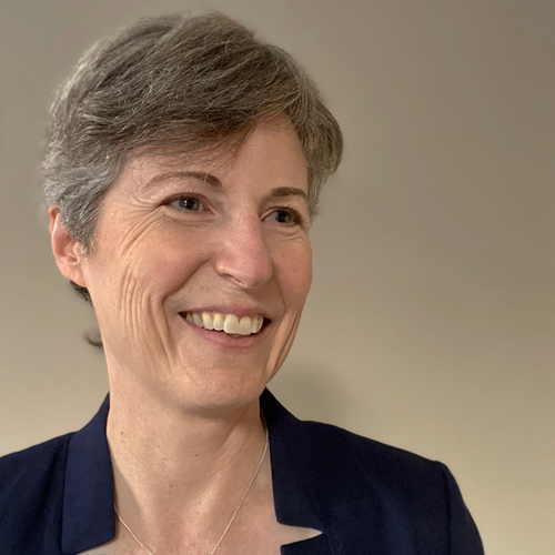 Susan Stevens, wearing a blue blazer and smiling away from the camera