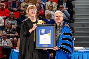 Dr. Juliette Valcke, standing on stage receiving the President and Vice-Presidents’ Advanced Career Teaching Award