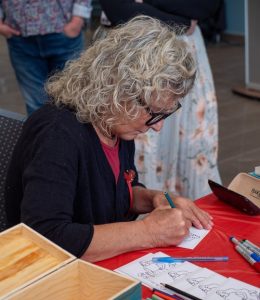 A staff member filling out a card at one of the stations at the Red Dress Day event