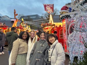 Suwela and 3 other students posing outside in a holiday market