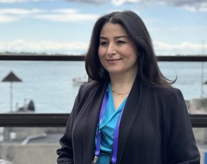 The Honourable Maryam Monsef, looking away from the camera on a pier