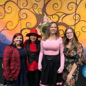 Krista Collier-Jarvis, Jessica Jerome, Grace Campbell-Leblanc, and Cheyenne Hardy, posing in front of the Two-Eyed Seeing Mural in the MSVU Library