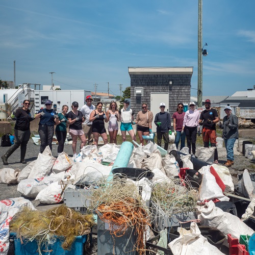 A group photo of all the participants, and the garbage that was collected, as part of the Coastal Cleanup Event