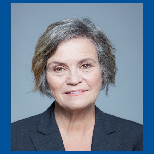 Jane Bertrand, wearing a gray suit jacket, smiling at the camera