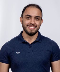 Dr. Dhesmon Lima, wearing a blue polo and smiling against a white background