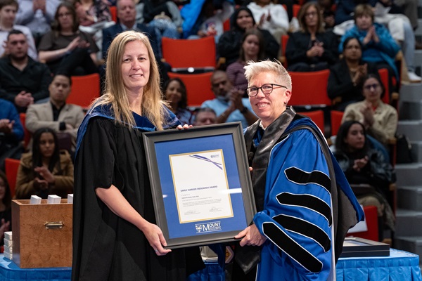 Catherine Baillie Abidi, receiving the Early Career Research Award from Dr. Joël Dickinson at the Fall 2026 Convocation Ceremony.