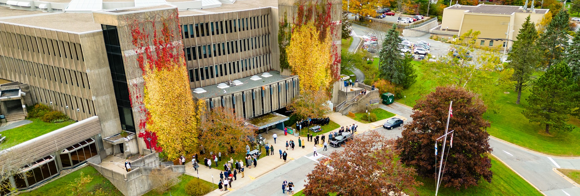 The exterior of Seton Academic Centre, in October, with the leaves on the trees turning a dark red and orange
