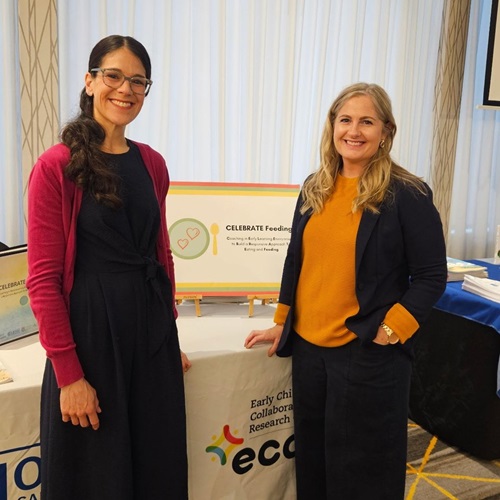 Dr. Jessie-Lee McIsaac and Dr. Misty Rossiter, standing in front of a ECCRC table at a research conference.